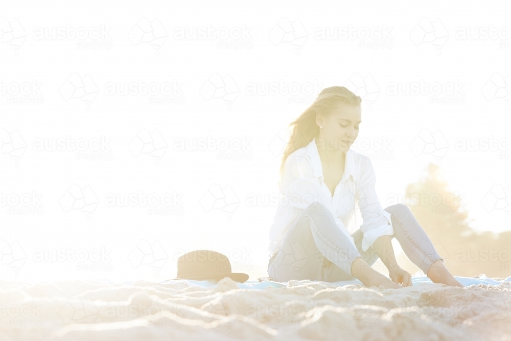 Carefree young blonde woman at beach enjoying the sunshine - Australian Stock Image