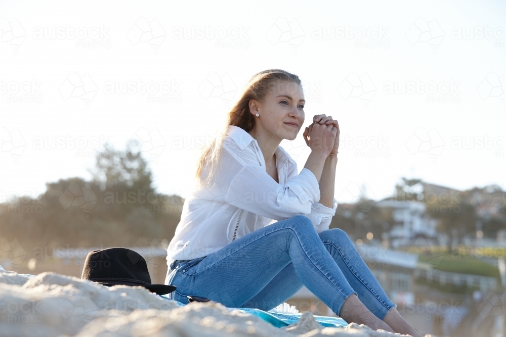Carefree young blonde woman at beach enjoying the sunshine - Australian Stock Image