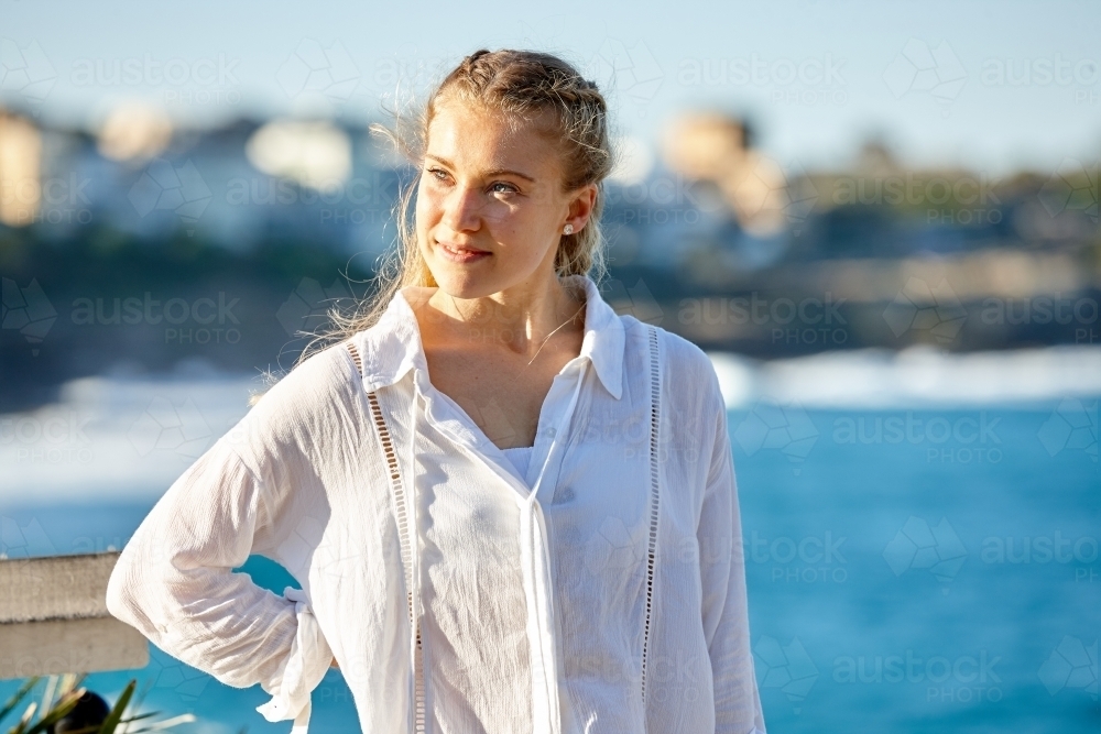 Carefree young blonde woman at beach enjoying the sunshine - Australian Stock Image