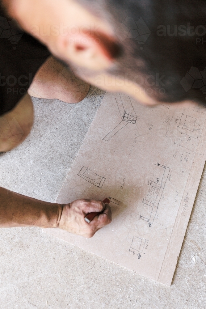 Carpenter doing construction hand sketch and drawing - Australian Stock Image