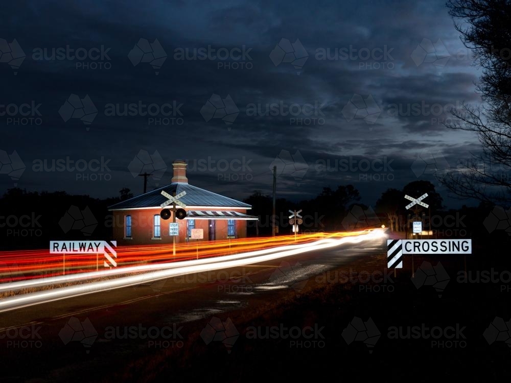 Cars crossing a railway crossing at night - Australian Stock Image