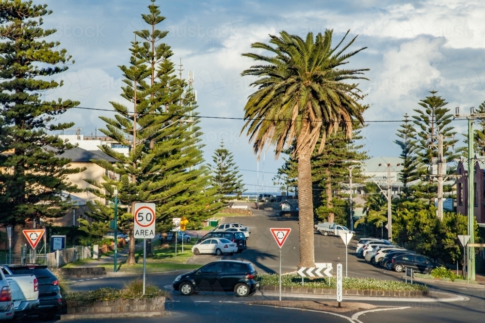Cars driving around a roundabout in coastal town - Australian Stock Image