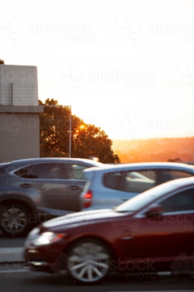 Image of Cars driving with sunset in the background - Austockphoto
