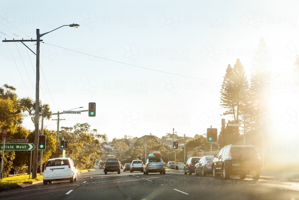 Cars in peak hour traffic approaching traffic lights on road in the afternoon - Australian Stock Image