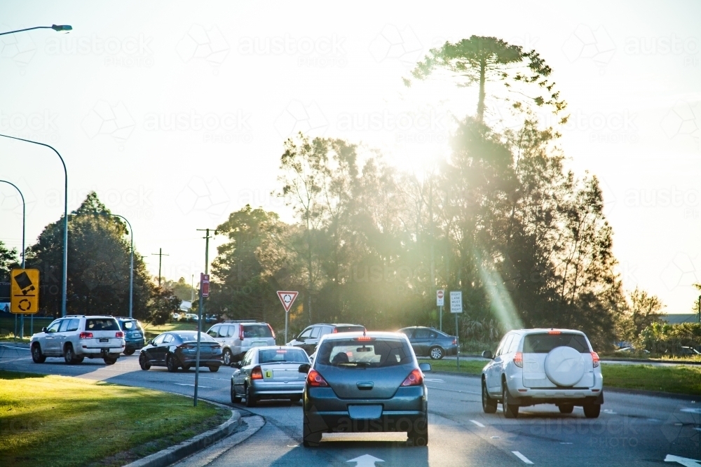 Cars in peak hour traffic driving on road in the afternoon - Australian Stock Image