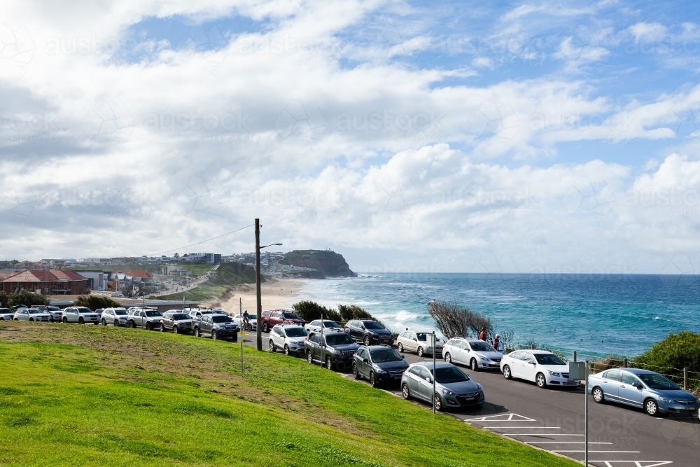 Cars parked along road beside beach - Australian Stock Image