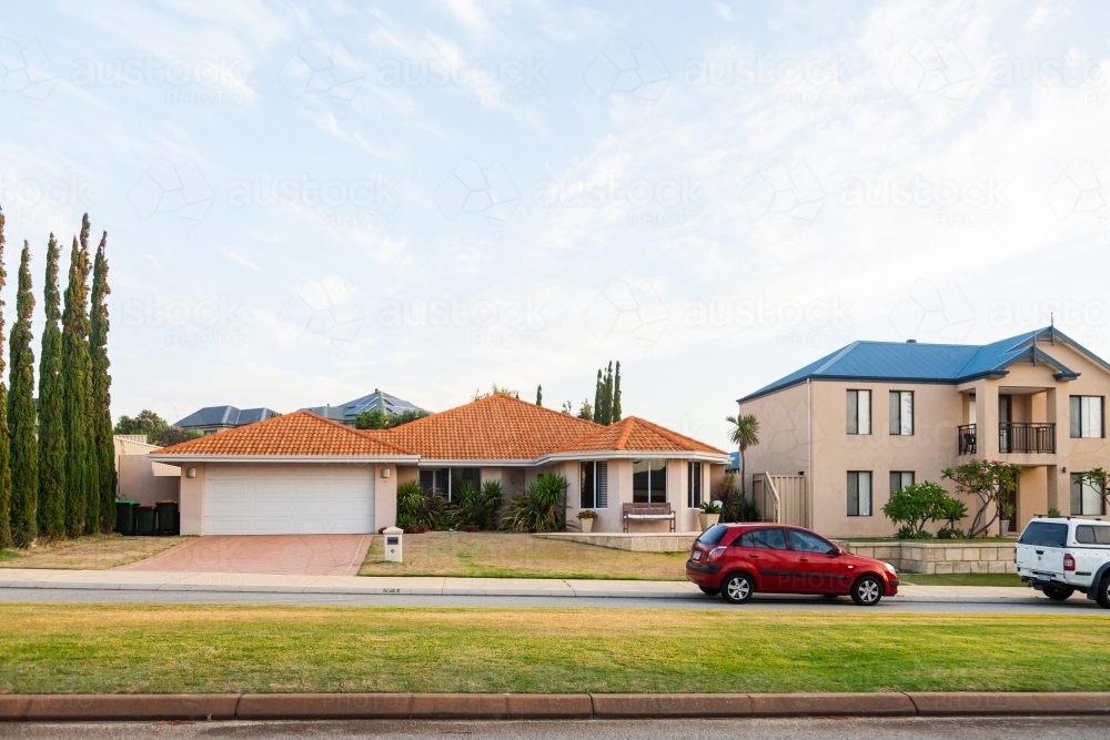 Cars parked beside the road and houses in coastal area - Australian Stock Image