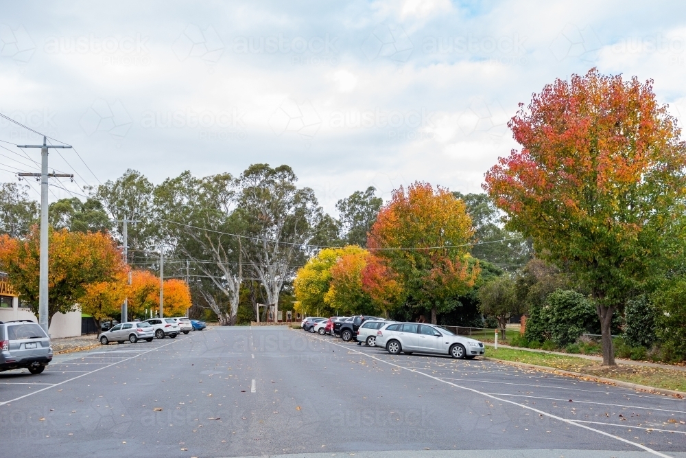 Cars parked in bays at the side of road in country town on overcast autumn day - Australian Stock Image
