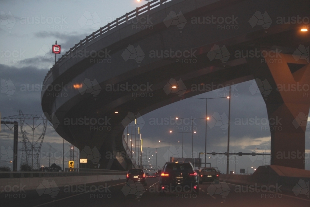 Cars passing under a bridge on Melbourne City roads in the evening - Australian Stock Image