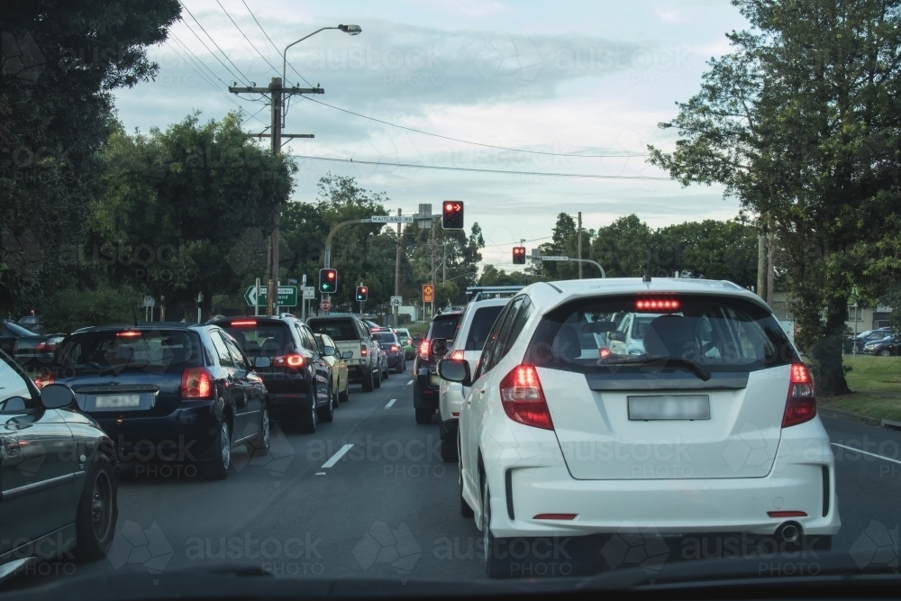 Cars stopped at red traffic light in urban peak traffic - Australian Stock Image