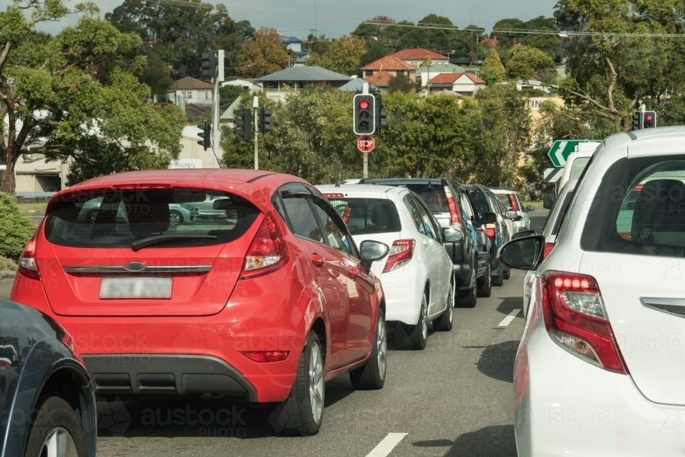 Cars stopped at red traffic lights in urban traffic in daylight - Australian Stock Image