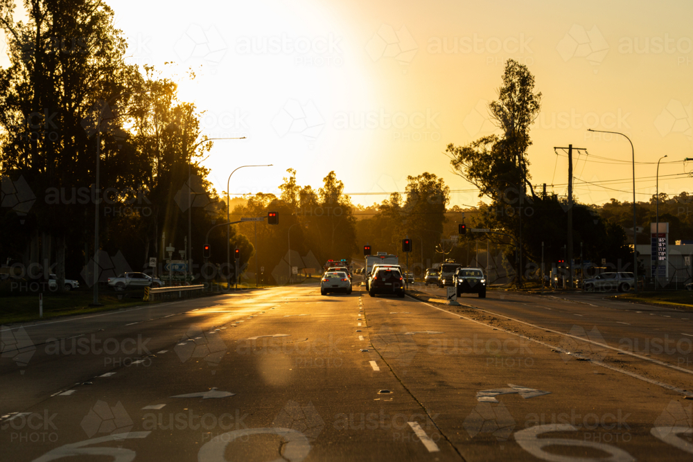 Cars stopped at traffic lights New England Highway in Singleton in golden sunset light - Australian Stock Image