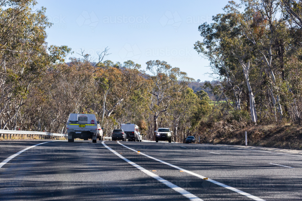 Vehicles In Rural Community Image of cars ute and caravan vehicles driving along rural highway in ...