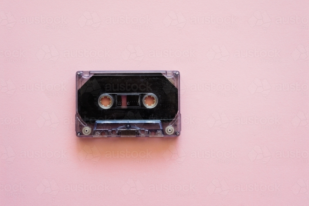 cassette music tape on pink background - Australian Stock Image