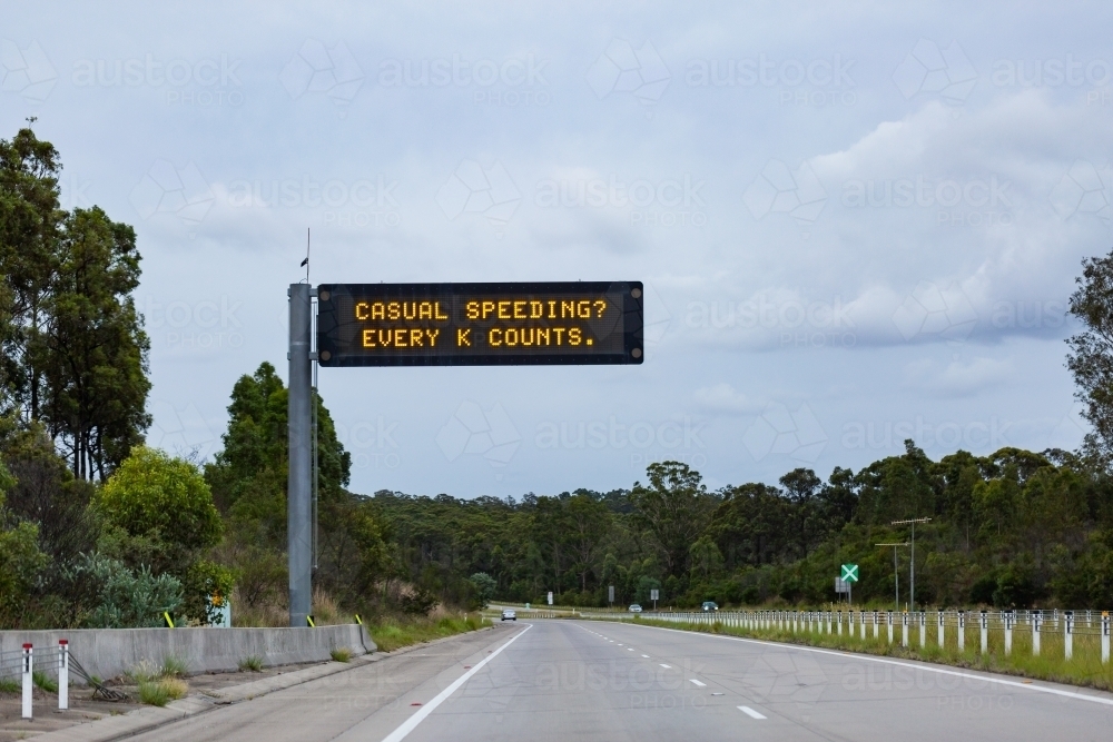 casual speeding? every k counts digital road sign above highway - Australian Stock Image