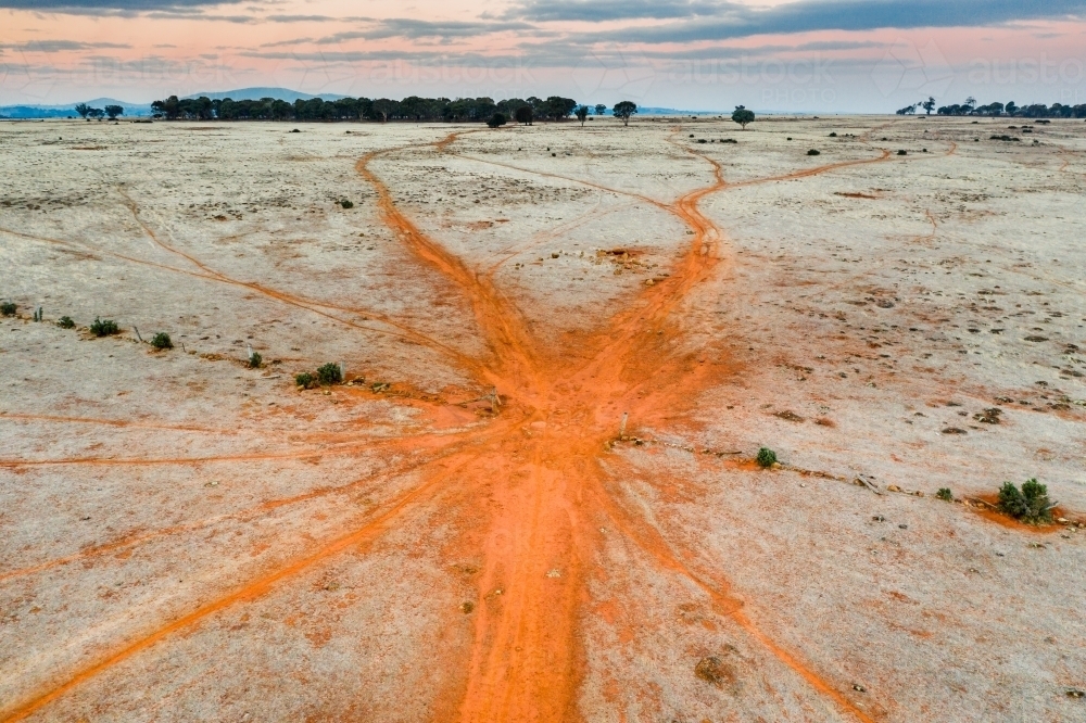 Cattle tracks in red dirt leading through a gateway - Australian Stock Image