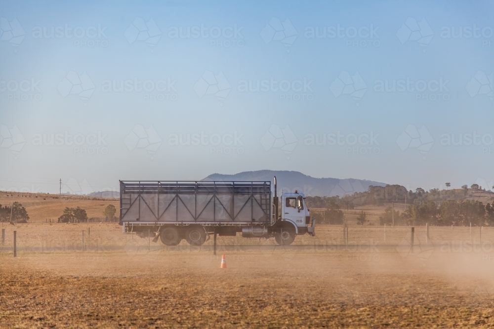 Cattle truck driving on road during dusty dry summer - Australian Stock Image