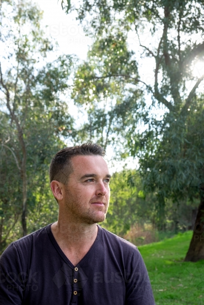 Caucasian male looking into the Distance surrounded by Trees - Australian Stock Image