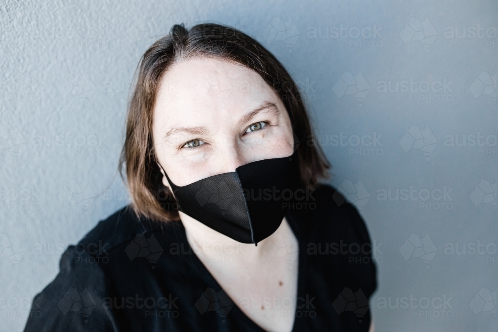 Caucasian woman wearing a black mask during the COVID-19 Coronavirus pandemic - Australian Stock Image