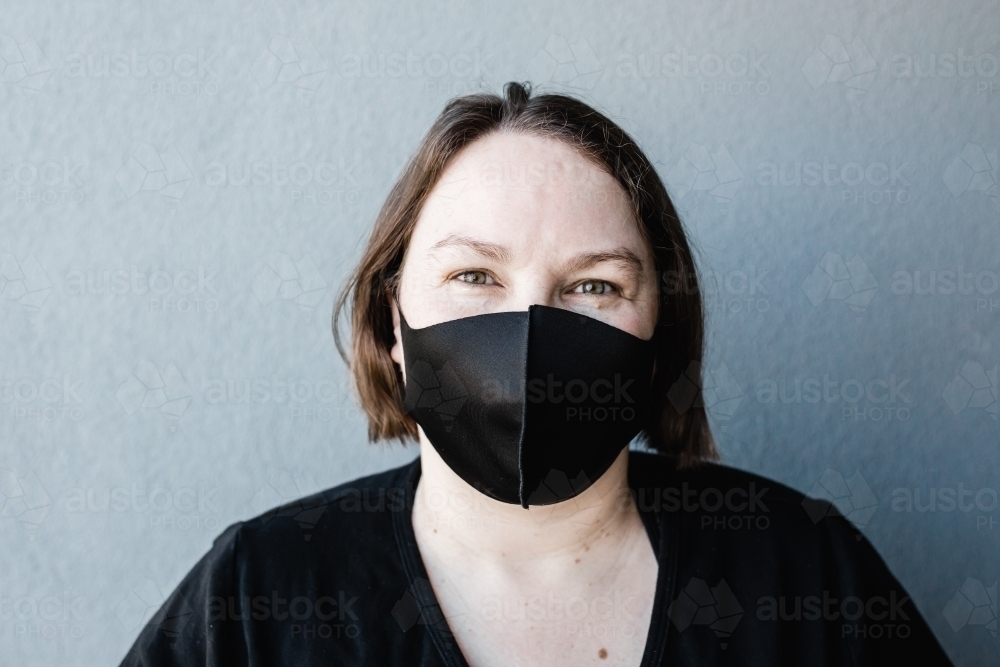 Caucasian woman wearing a black mask during the COVID-19 Coronavirus pandemic - Australian Stock Image