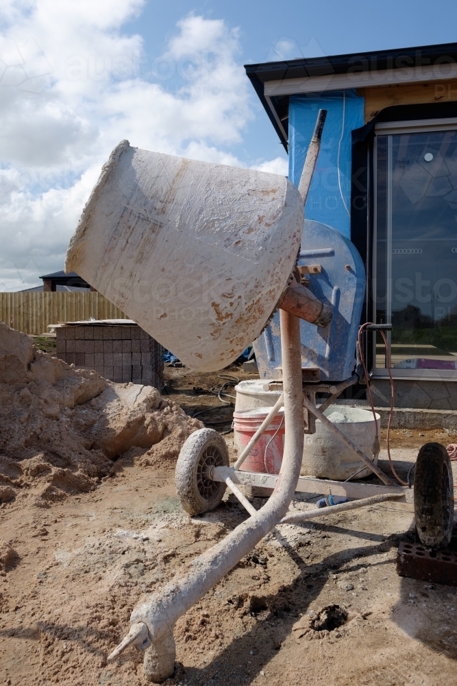 Image of Cement mixer in front of new house build Austockphoto