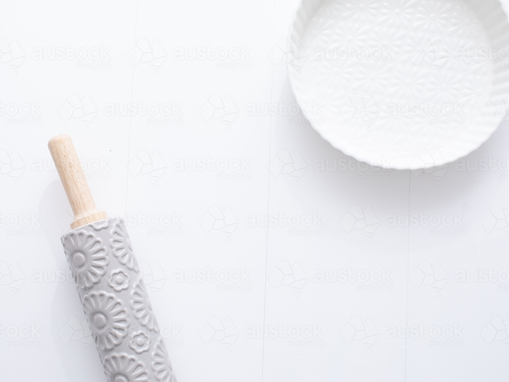 Ceramic pie dish and rolling pin on blank background - Australian Stock Image
