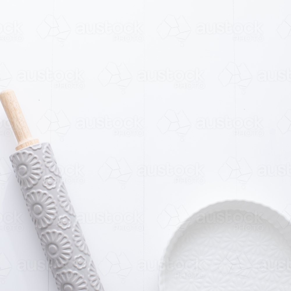 Ceramic pie dish and rolling pin on blank background - Australian Stock Image