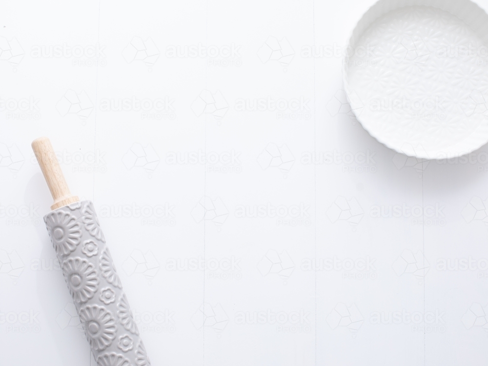 Ceramic pie dish and rolling pin on blank background - Australian Stock Image