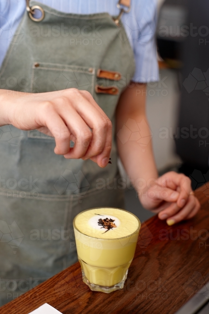 Chai and turmeric tea latte prepared on table in cafe - Australian Stock Image
