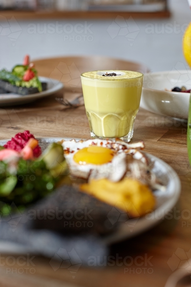 Chai latte and healthy lunch on table in cafe - Australian Stock Image