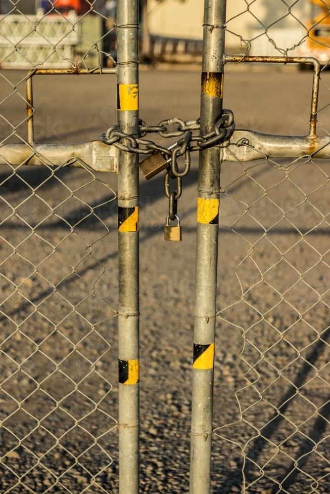 Chain and padlocks holding a gate in an industrial state closed - Australian Stock Image