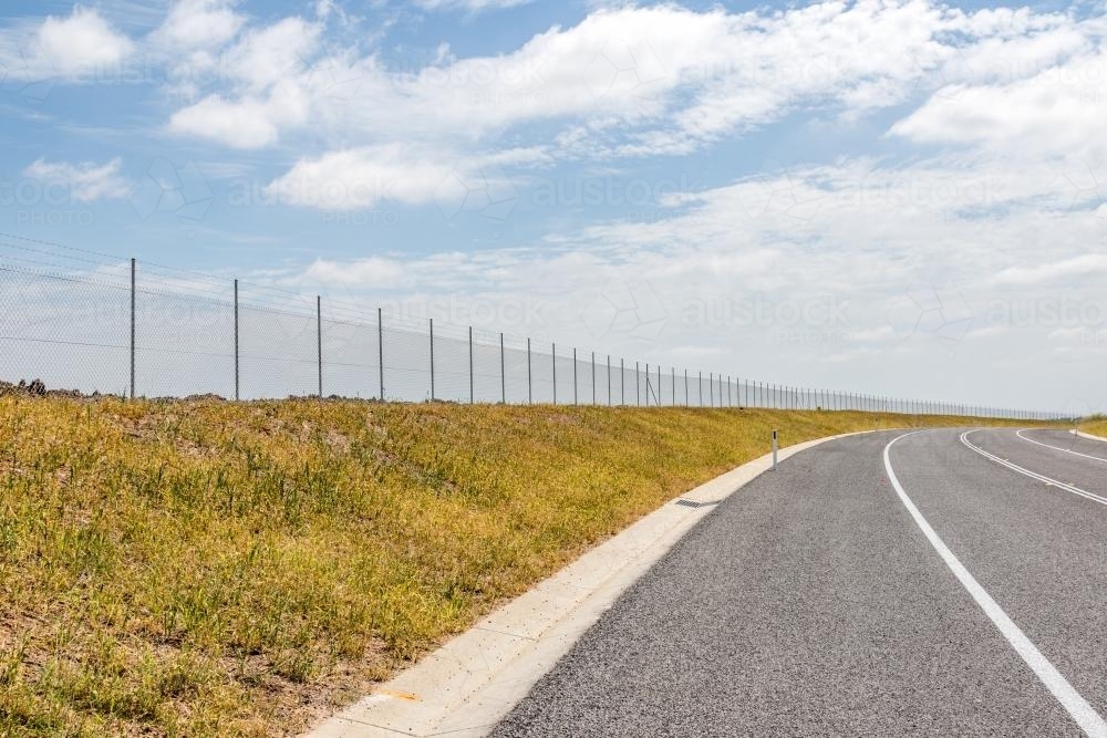 Chainwire fence along road - Australian Stock Image
