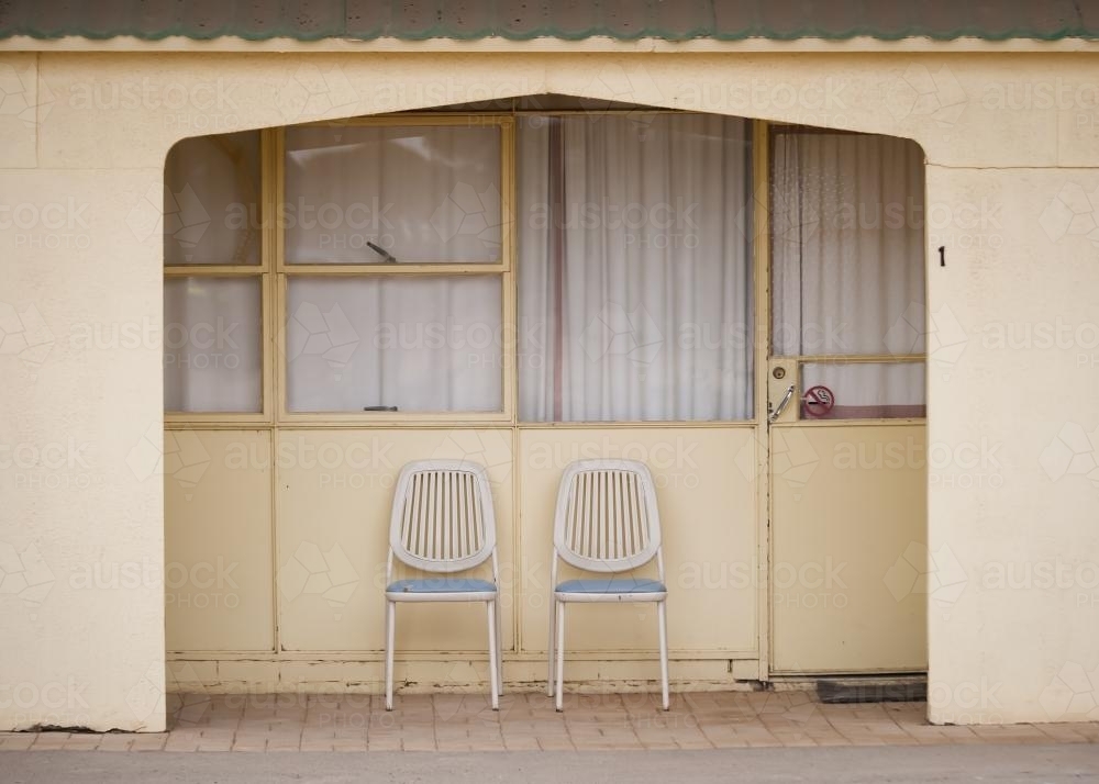 Chairs outside a pale yellow motel room on the Nullarbor - Australian Stock Image
