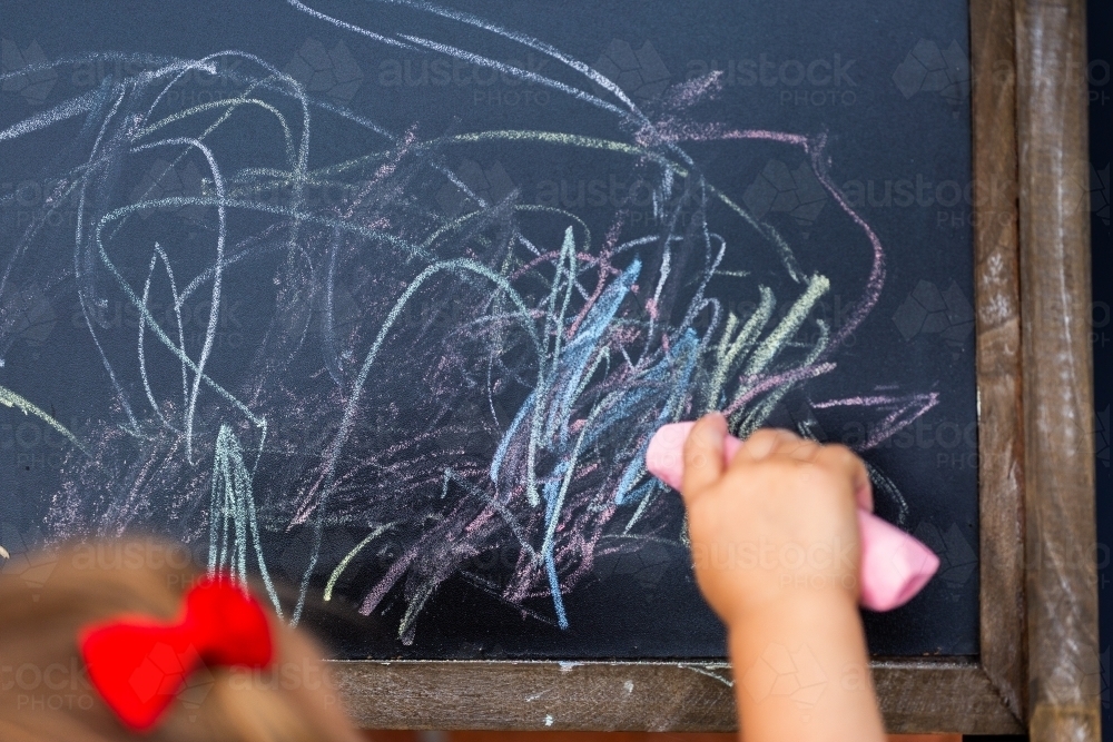 Chalk scribbles of young child drawing on blackboard - Australian Stock Image