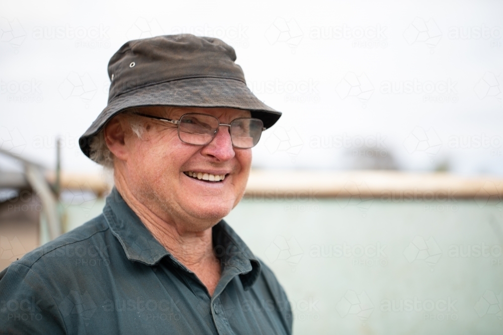 cheerful older gent outdoors wearing glasses and bucket hat - Australian Stock Image