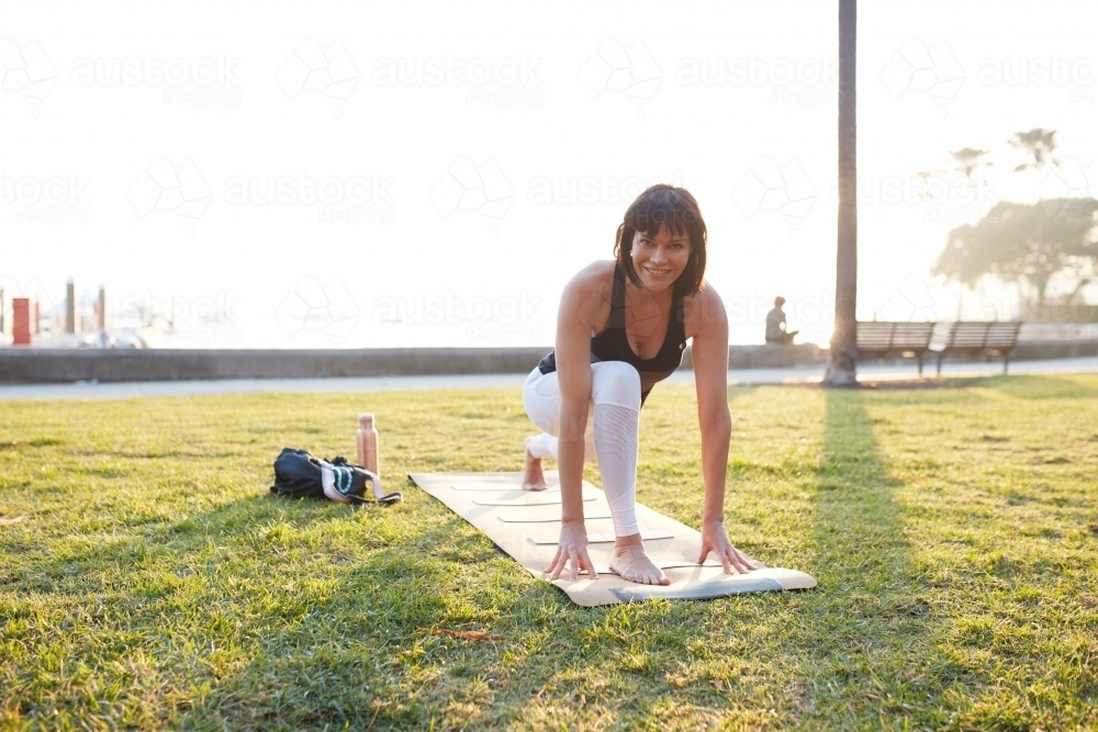 Cheerful woman practising yoga outdoors - Australian Stock Image