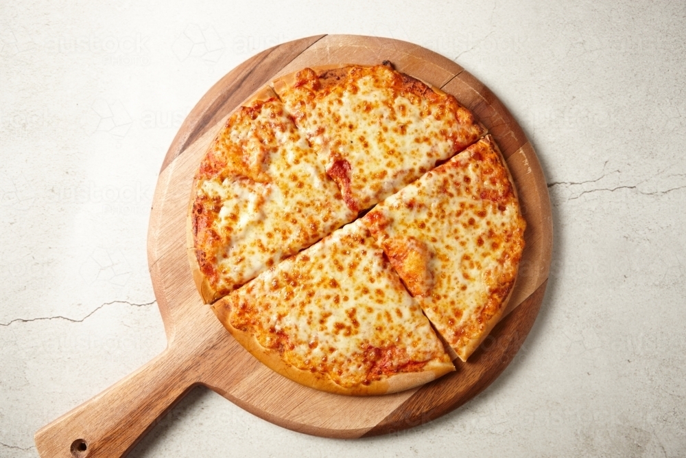 Cheese and tomato pizza on board - Australian Stock Image