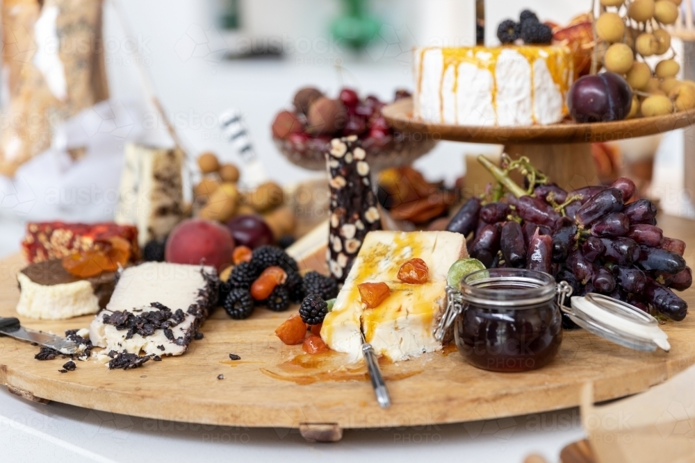 cheese board filled with cheeses and fruits - Australian Stock Image