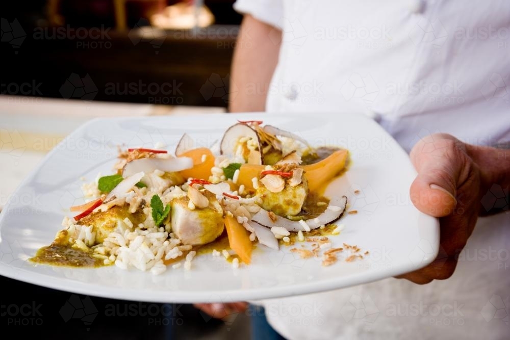 chef holding plate of food - Australian Stock Image