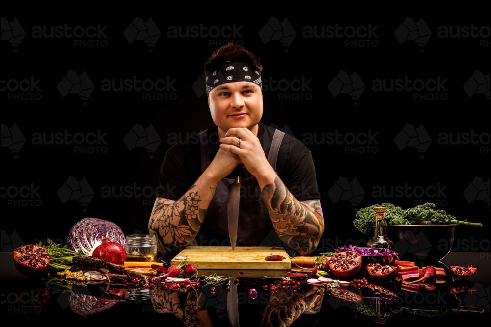 Chef portriat, with colourful salad ingredients, chopping board and knife - Australian Stock Image