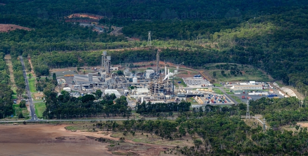 Chemical plant with The Narrows mud flats in the foreground, Gladstone, Queensland - Australian Stock Image