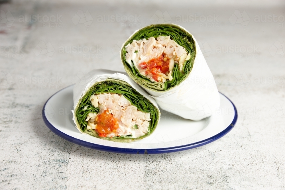 Chicken and lettuce wrap served on a plate in cafe - Australian Stock Image