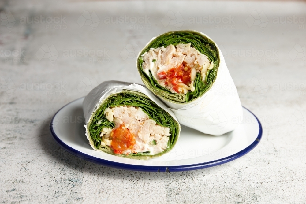 Chicken and lettuce wrap served on a plate in cafe - Australian Stock Image