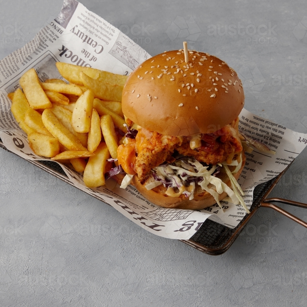 Chicken burger and chips on table - Australian Stock Image