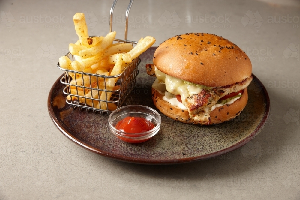 Chicken burger with chips on plate - Australian Stock Image
