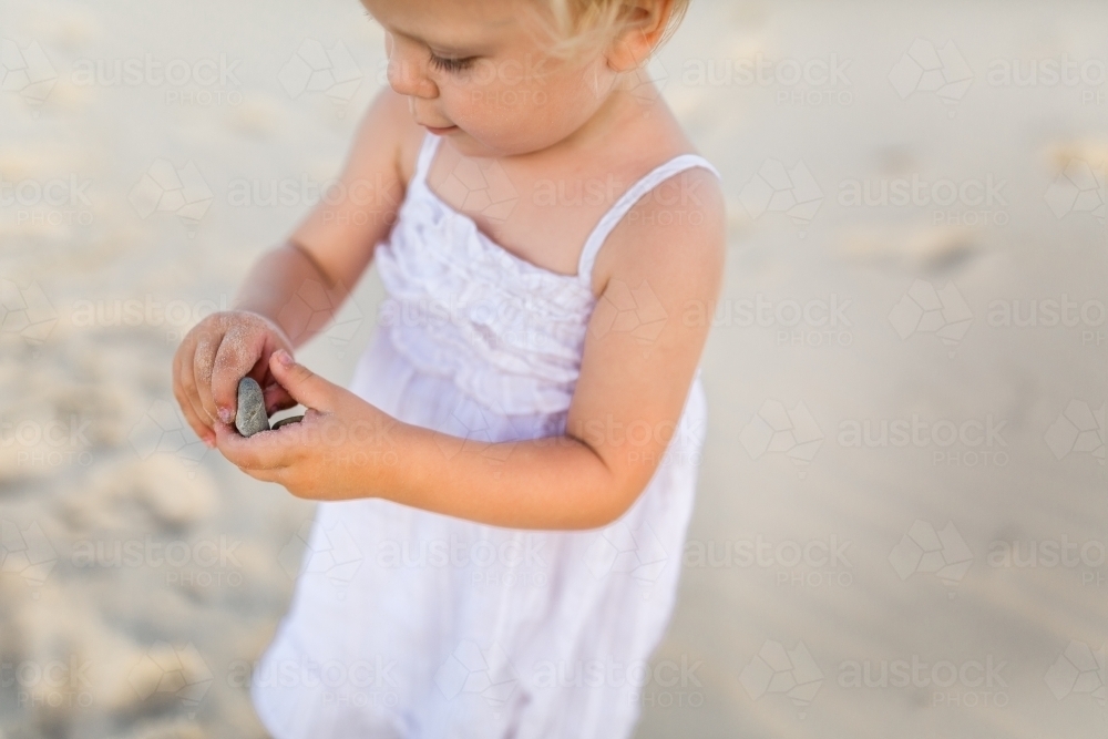 Child collecting shells at the beach - Australian Stock Image