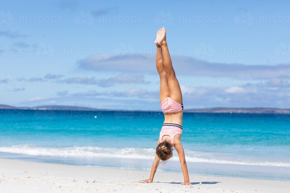 child doing handstand on the beach - Australian Stock Image