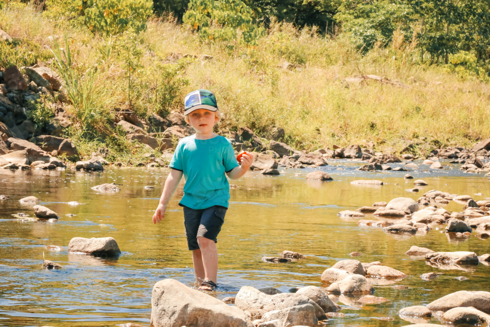 Image of Child exploring rocky North Queensland creek eating apple ...