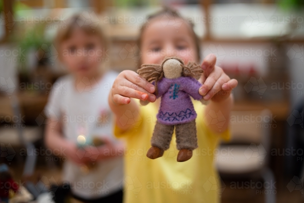 Child holding international felt doll - Australian Stock Image