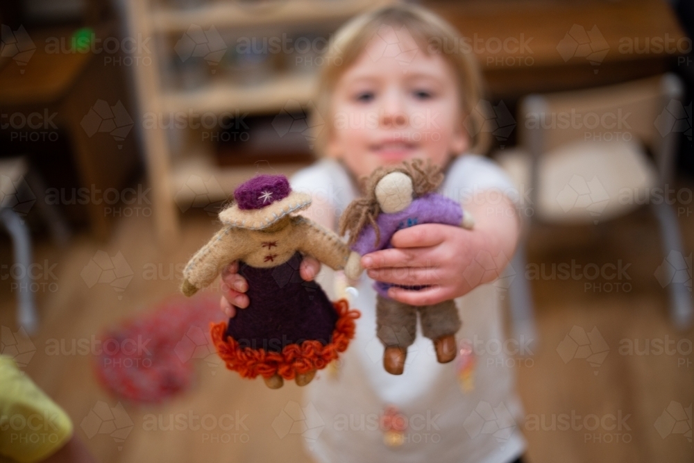 Child holding international felt dolls - Australian Stock Image